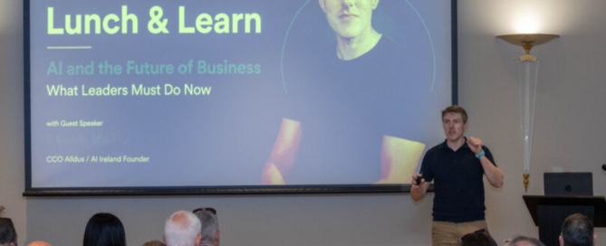 Mark Kelly presenting “AI and the Future of Business” at a County Kildare Chamber Lunch & Learn event to a seated audience. Unlock AI Process Transformation