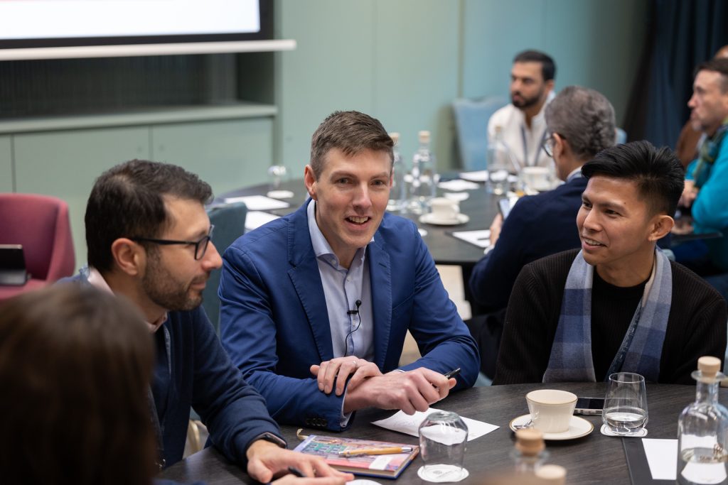 Mark Kelly leading an executive AI workshop roundtable with business leaders at a boardroom table
