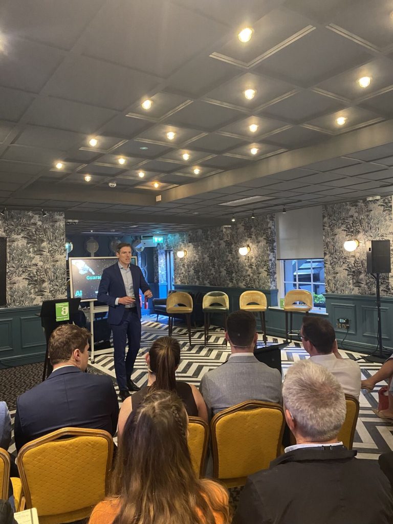Mark Kelly delivering an AI keynote to business leaders at a Guaranteed Irish event